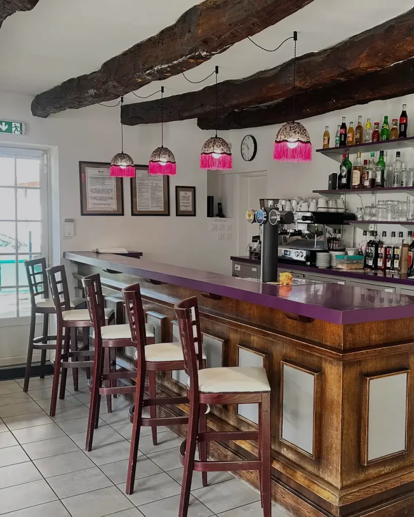 Salle avec comptoir de bar, étagères de bar avec verres et bouteilles